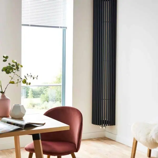 Modern black vertical radiator in a bright, stylish interior.