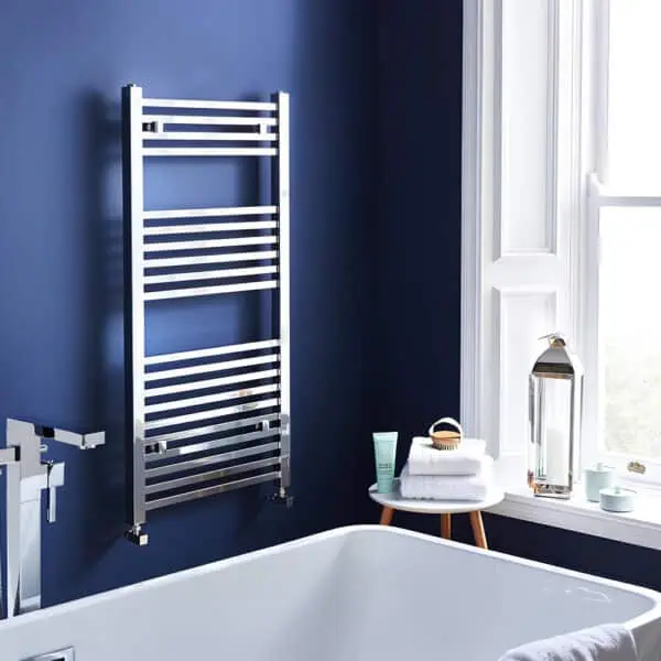 Modern stainless steel towel radiator in bathroom interior.