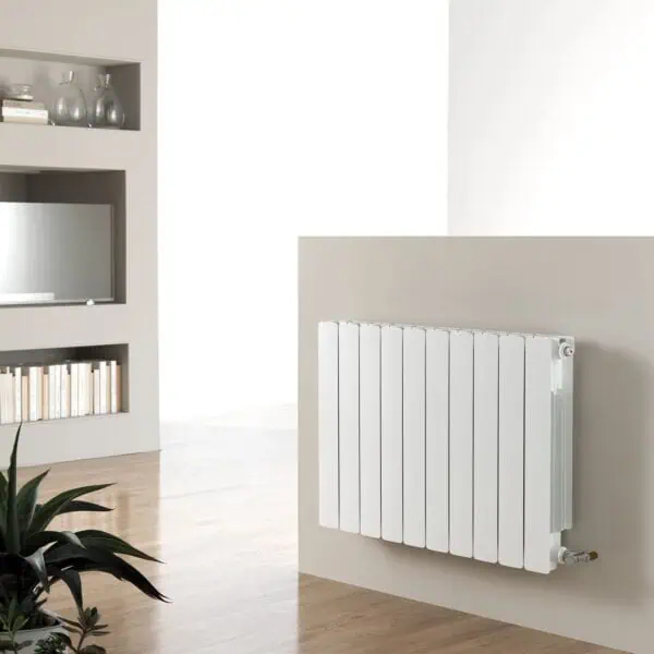 Radiator heating panel in modern minimalist interior with wooden flooring and built-in bookshelves.