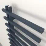 Black metal radiators mounted on a wall for heating systems.