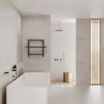 Sleek modern bathroom with minimalist design, featuring a white bathtub, gold fixtures, and wooden accents.