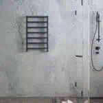 Minimalist modern bathroom with black towel rack and walk-in shower. Marble wall design creates an elegant look.